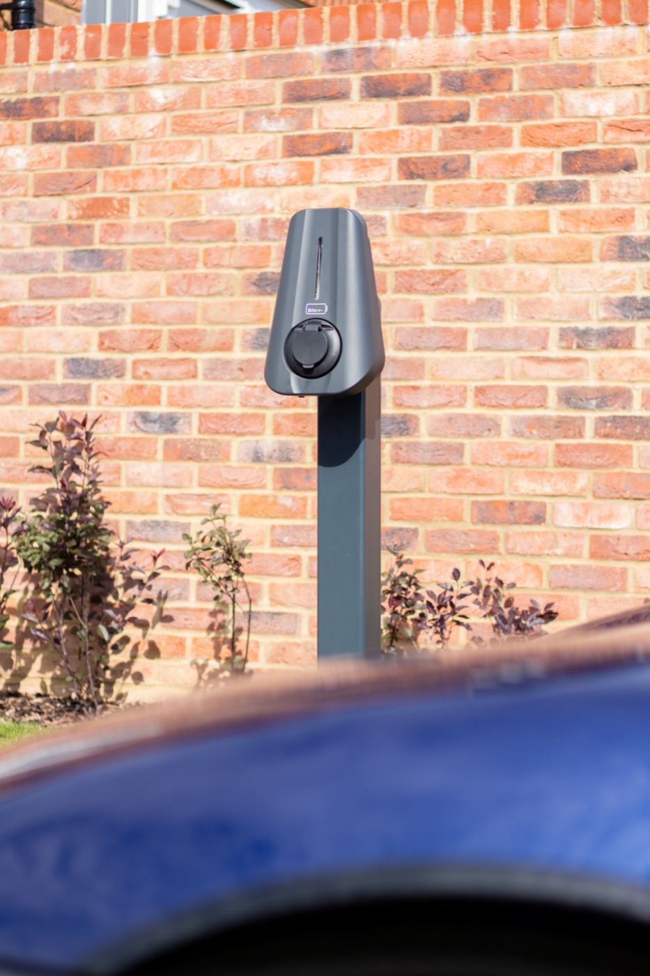Brim charger on a post beside the brick wall of a new-build home